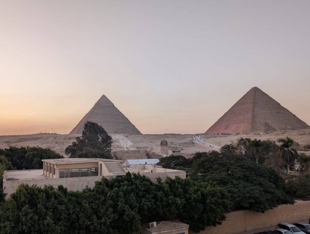 夕暮れ時の空の下に佇む、ギザのピラミッドとスフィンクス