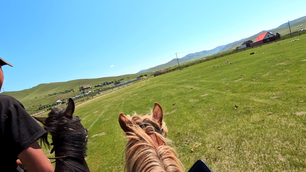 モンゴルの草原での乗馬体験 前の馬と並ぶ私の馬