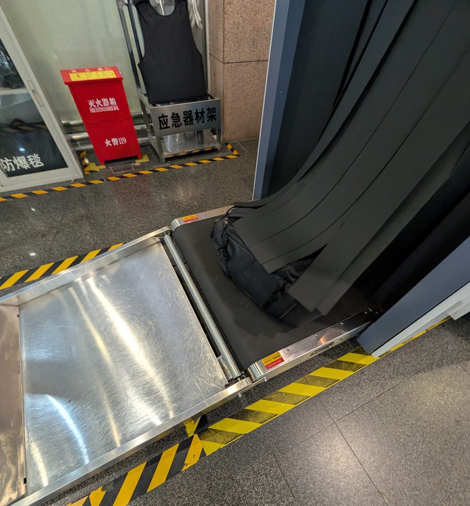 荷物検査の機械から荷物が出てくる写真
