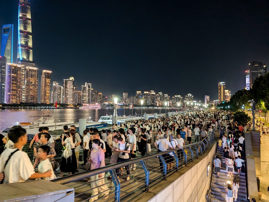 外灘の遊歩道を埋める人波と、対岸の上海中心・環球金融中心