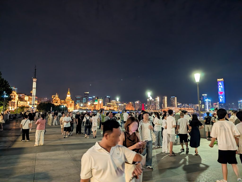 外灘の遊歩道から見た白い気象信号台と、奥に金色に光る万国建築群