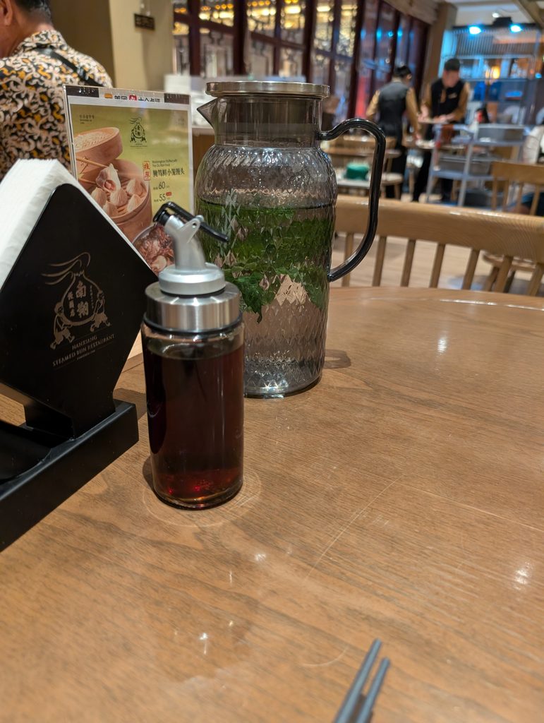 卓上には緑の葉が入った大きな水差しと、黒酢のボトル