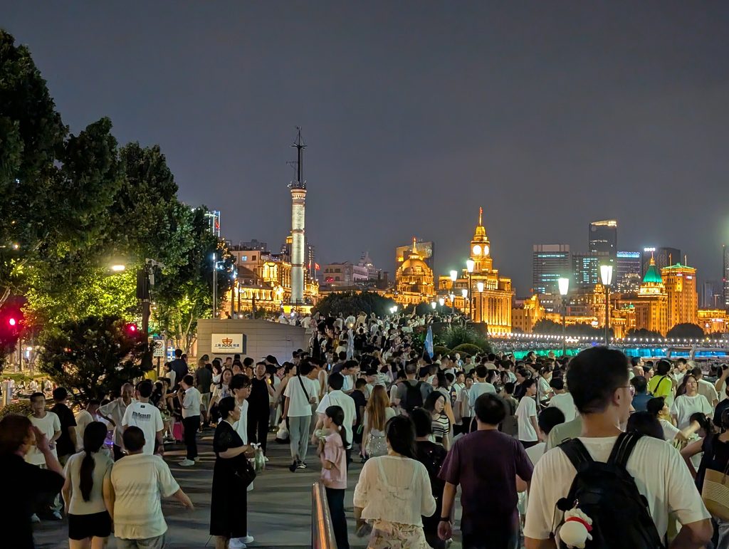 外灘の遊歩道を埋める人と、奥に見える気象信号台・万国建築群